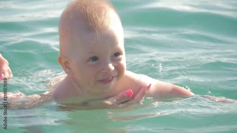 Mom and baby are swimming in the sea. Mom and baby are swimming in the sea.