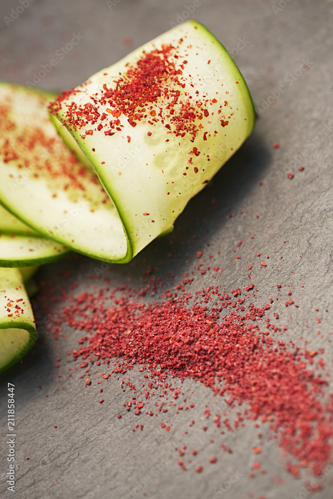 Ground Red Sumac Berries sprinkled on cucumber slice Stock Photo Adobe Stock