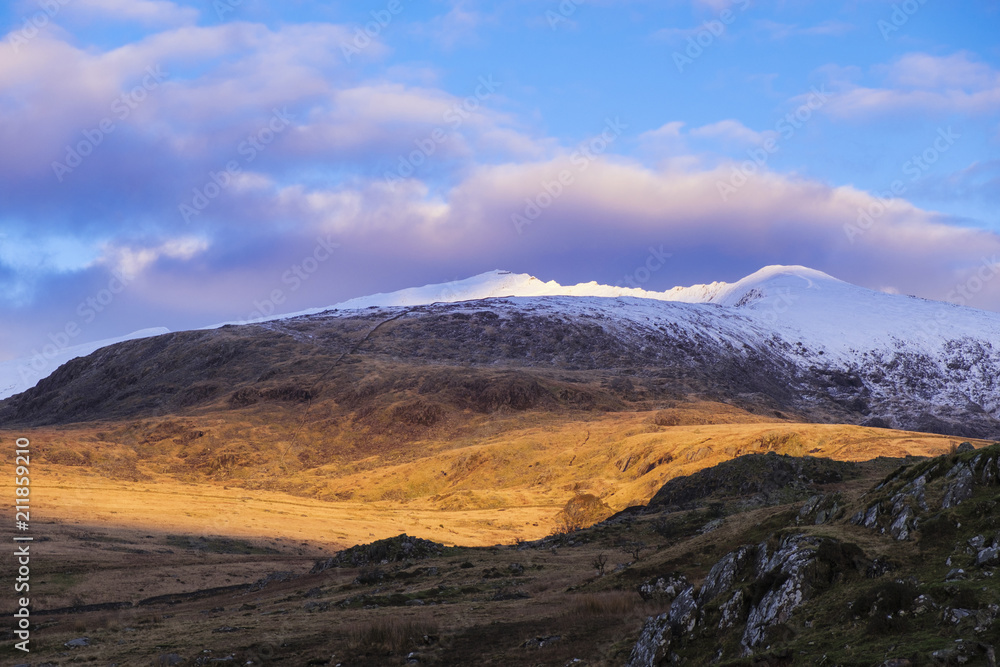 Late afternoon view to snow capped Mount Snowdon in winter in Snowdonia National Park, Rhyd Ddu, Gwynedd, Wales Late afternoon view to snow capped Mount Snowdon in winter in Snowdonia National Park, Rhyd Ddu, Gwynedd, Wales