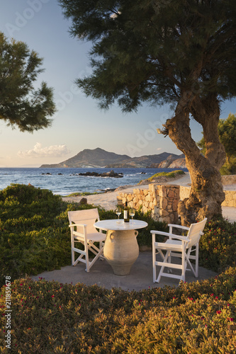 White wine bottle and glasses on table at Nefeli Sunset Studios, Pollonia, Milos, Cyclades, Aegean Sea, Greek Islands, Greece photo