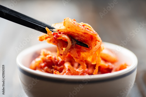 Kimchi cabbage in a bowl with chopsticks for eating, Korean food