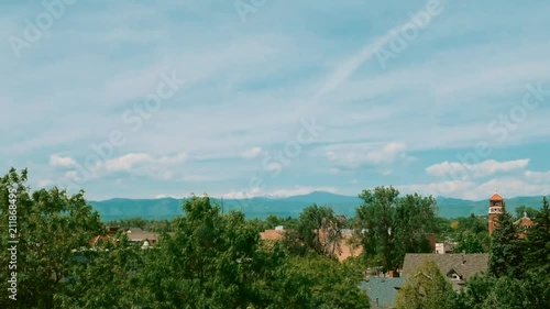 A summer morning time-lapse of the clouds over the city with the Rocky Mountains in the background. photo