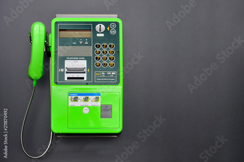 green public telephone on black background, copy space