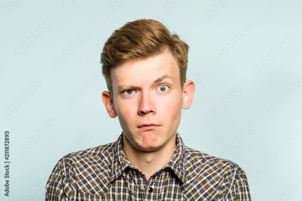 puzzled confused bewildered shocked amazed man. comical reaction. portrait of a young guy on light background. emotion facial expression and feelings concept. puzzled confused bewildered shocked amazed man. comical reaction. portrait of a young guy on light background. emotion facial expression and feelings concept.