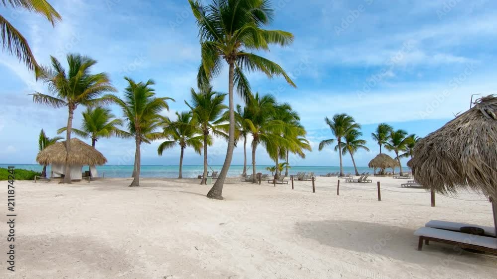 Dominican Republic Punta Cana. Beautiful beach. Sun umbrellas, chaise lounges / Evening on the beach of Punta Cana. Beautiful palm trees against the sky. Dominican Republic Punta Cana. Beautiful beach. Sun umbrellas, chaise lounges / Evening on the beach of Punta Cana. Beautiful palm trees against the sky.