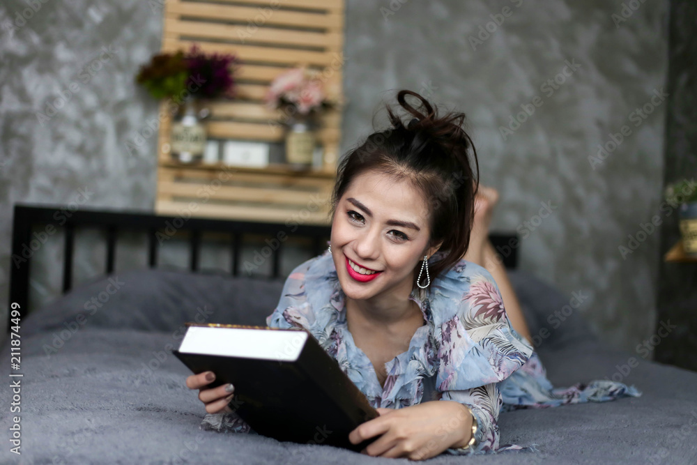 Obraz premium Beautiful Charming woman Smile face close up and she lying on the bed in the morning reading a book