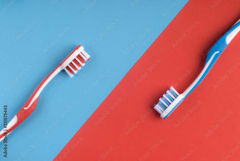 Red and blue toothbrushes on a colorful background Red and blue toothbrushes on a colorful background