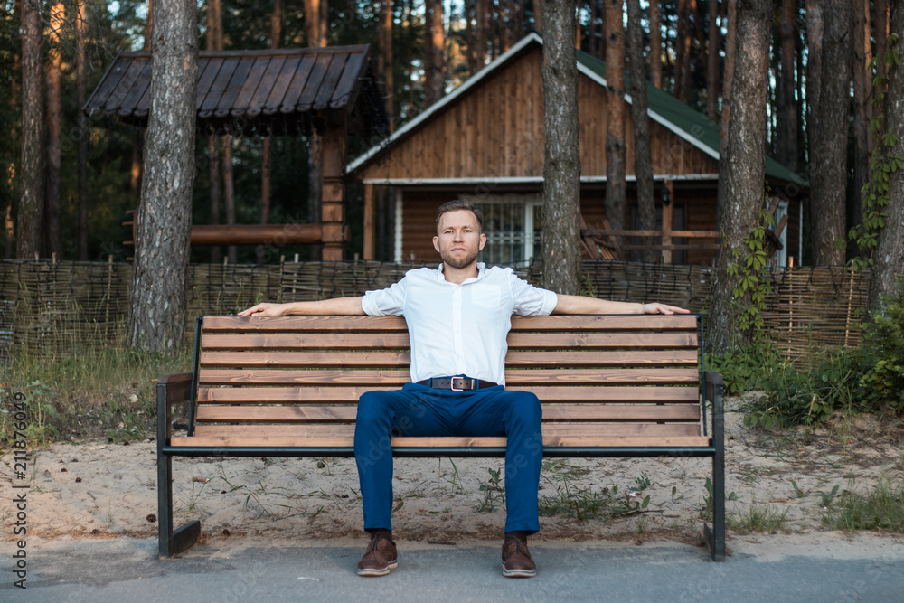 Fototapeta premium young man resting on a bench in the Park
