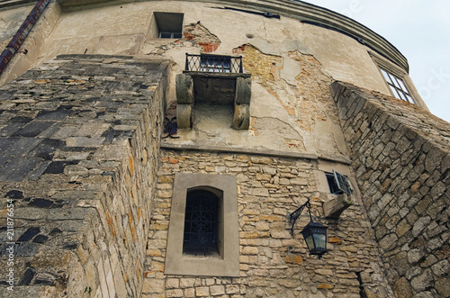 View of high wall with window and embrasure  in ancient Olesko castle. Lviv region in Ukraine. Cloudy summer day photo