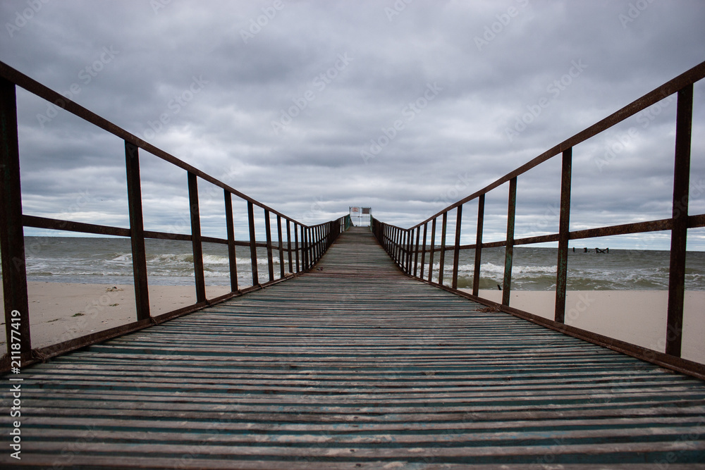 Fototapeta premium Wooden pier at sea. Gloomy weather.