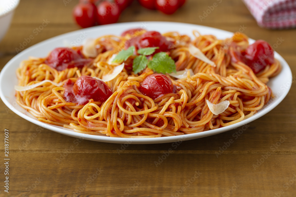 spaghetti with tomato sauce in the dish on the wooden table spaghetti with tomato sauce in the dish on the wooden table