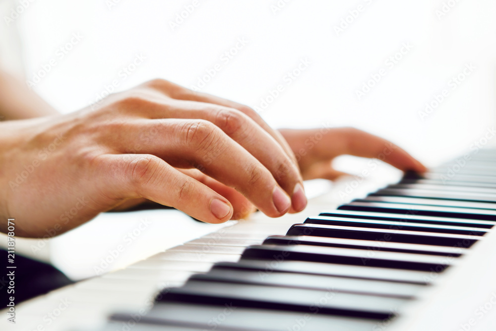 Fototapeta premium Close up of pianists hand playing piano. Shallow deep of field.