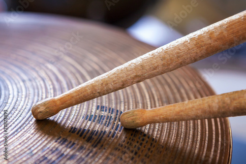 Pair of drumsticks lying on cymbal.