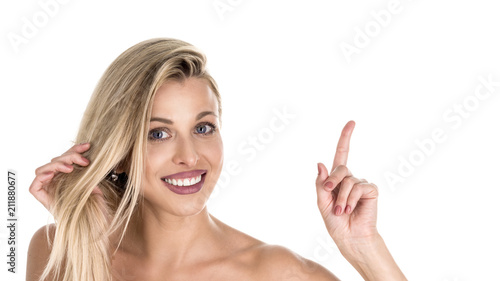Positive glad female says: wow how exciting it is, has amazed expression, indicates at blank copy space for your advertisment or promotional content. Joyful pretty young woman demosntrates something