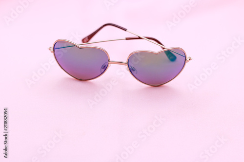 Heart sun glasses on pink background. Fashion and summer concept.