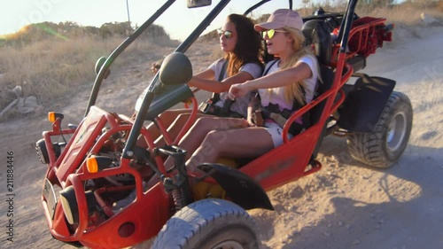Female driver ride on buggy car. Enjoy extreme riding. Tourists driving dune buggy. Extreme holiday. Women drive on sand buggy car. Girl driving dune transport photo
