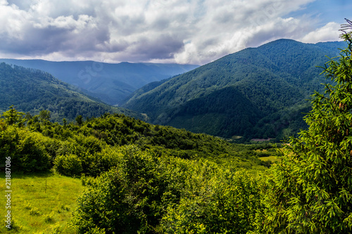 he top of the beautiful mountains overgrown with green and dense forest and heavy clouds on the horizon