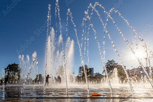 Unidentified Kids playing in the fountain in city park