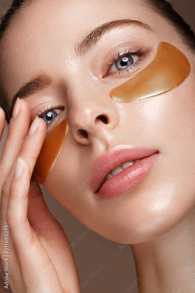 Beautiful fresh girl with cosmetic patches under the eyes, perfect skin and natural make-up. Beauty face. Photo taken in the studio. Beautiful fresh girl with cosmetic patches under the eyes, perfect skin and natural make-up. Beauty face. Photo taken in the studio.