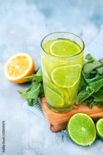 Yellow and green cocktail with lime, lemon and strawberry top view. Blue background. Copy space for text.