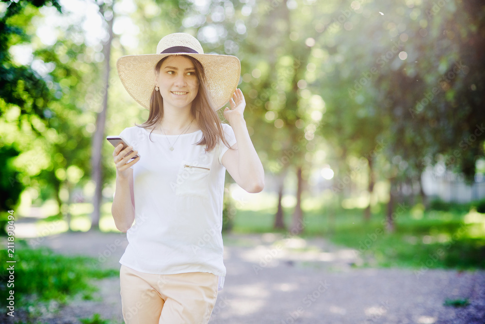 Happy girl with phone in hands, with hat on head