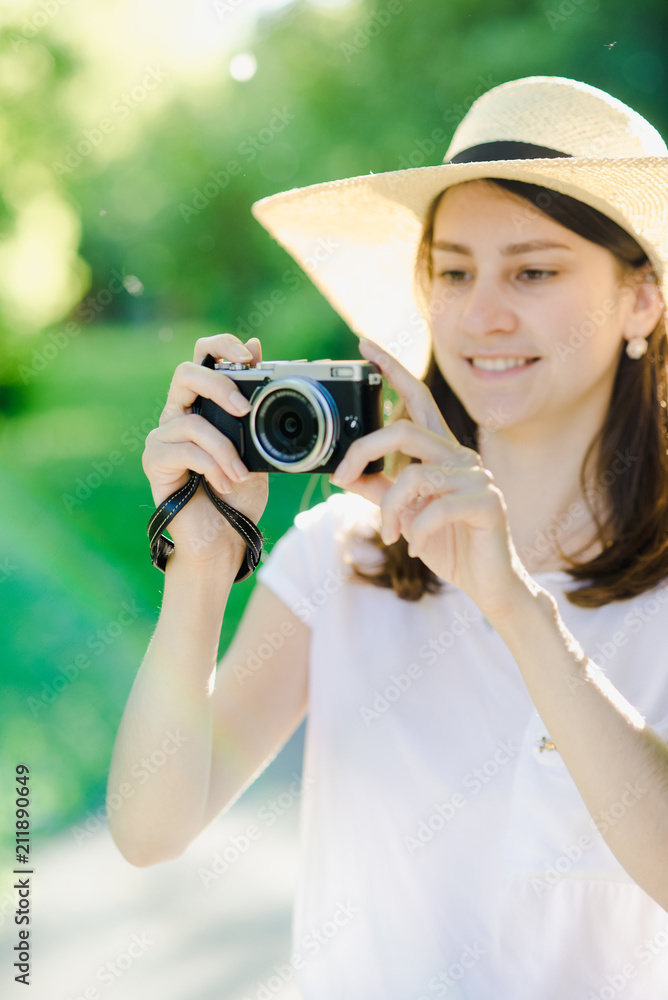 A girl with a camera in her hands, with a hat on her head A girl with a camera in her hands, with a hat on her head