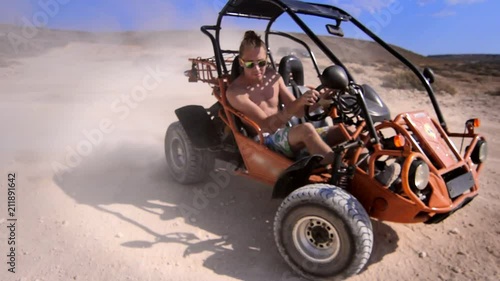 Driver man ride on sand buggy car in desert. Close up of extreme man riding on desert car around. Summer extreme. Desert racing car. Hipster man enjoy safari travel. Extreme holiday