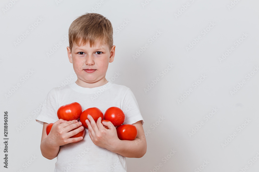 boy in a white t-shirt with tomatoes in the hands boy in a white t-shirt with tomatoes in the hands