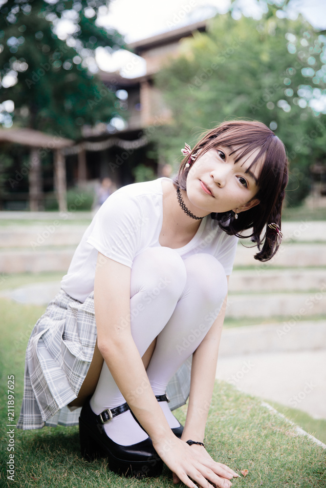 portrait of asian girl with white shirt and skirt sitting in outdoor nature vintage film style