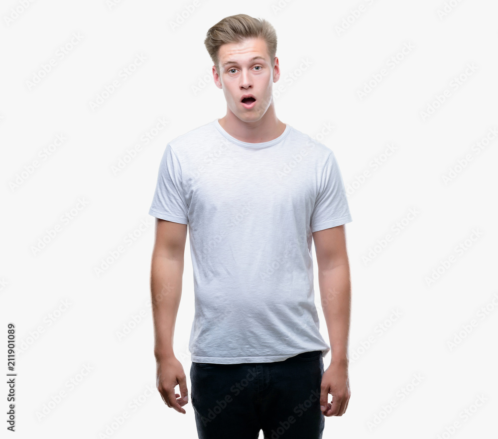 Young handsome blond man scared in shock with a surprise face, afraid and excited with fear expression Young handsome blond man scared in shock with a surprise face, afraid and excited with fear expression