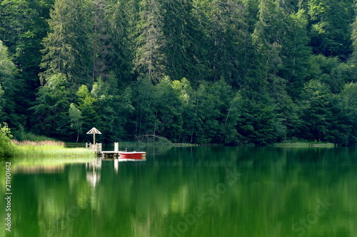 Mountain lake in the forest with a boat