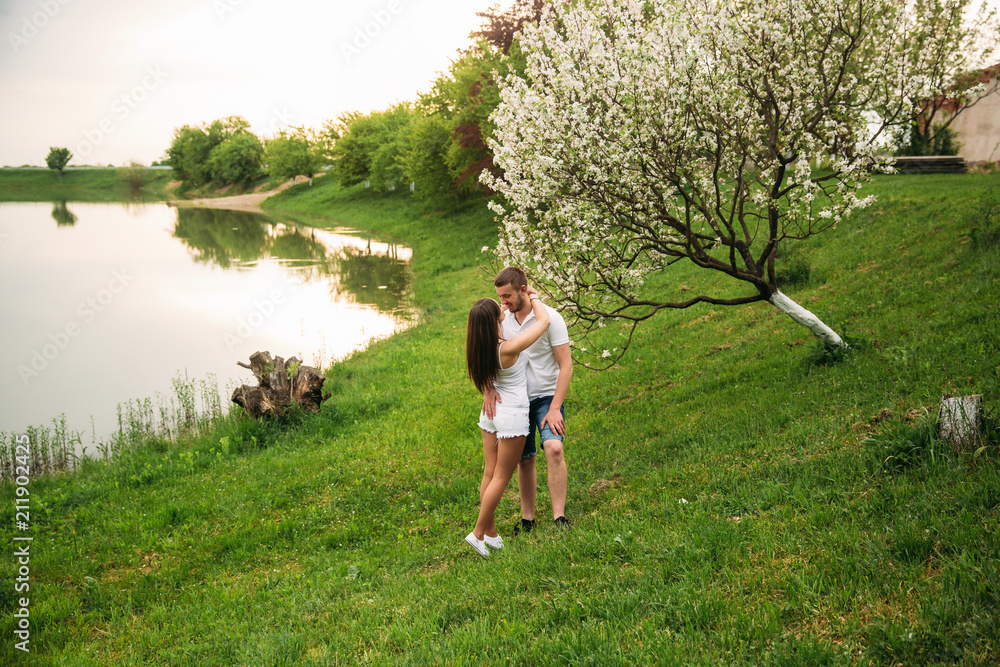 Dating in park. Love couple standing together on grass near the lake. Romance and love Dating in park. Love couple standing together on grass near the lake. Romance and love