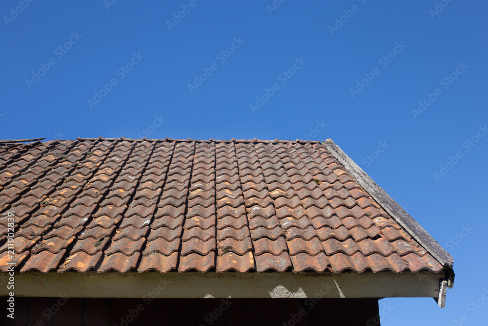 Old red roof tiles with beautiful blue sky background Old red roof tiles with beautiful blue sky background