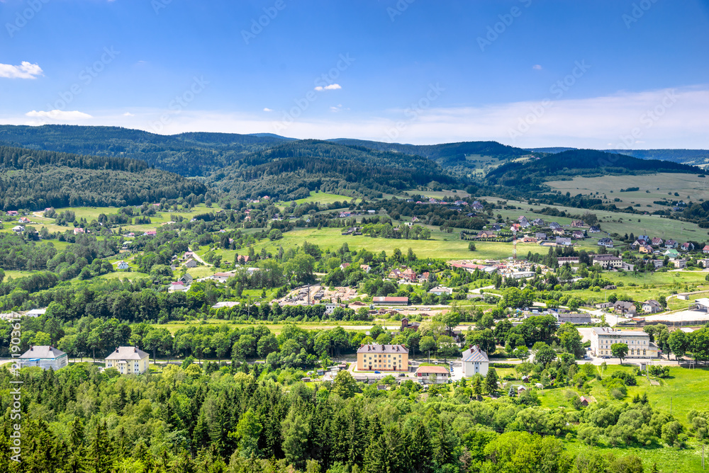 Mountain town in the valley with green and houses, aerial view