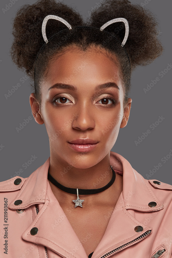 A close up portrait of a young African lady in a jacket, with curly hair,  double