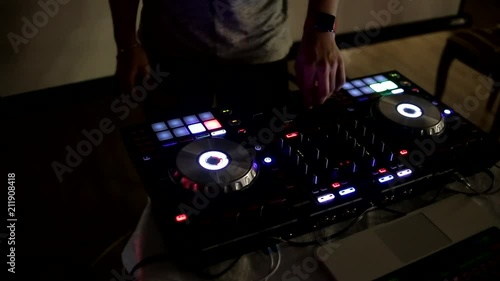 Close-up video of the work of a DJ, playing music in a nightclub, a mixing console. Handles sound card. The modern profession