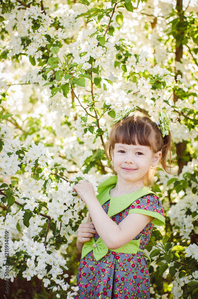 happy little girl in a blooming garden happy little girl in a blooming garden