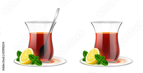 Turkish transparent tea cup with black tea, silver spoon, mint and lemon