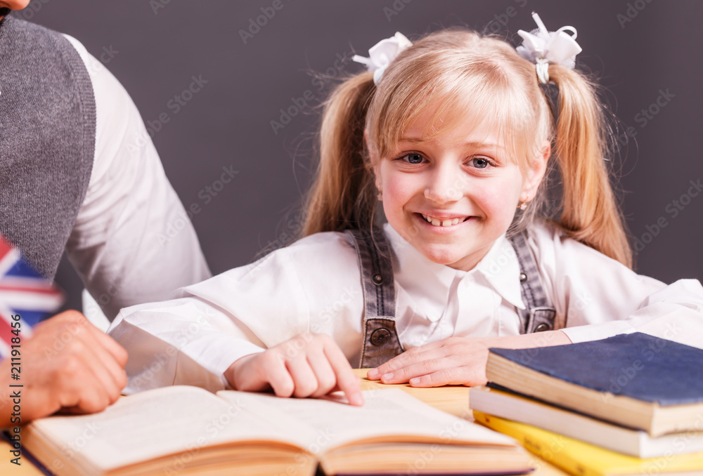 Successful kid student girl smile while reading English book with teacher help Successful kid student girl smile while reading English book with teacher help