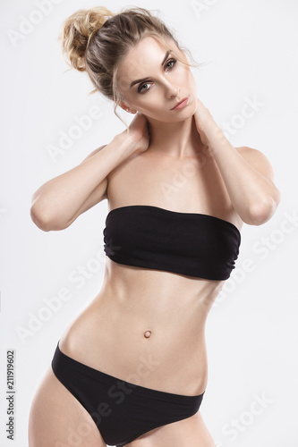 Portrait of a cute young girl in a black short top. Studio breast portrait of an attractive model with perfect skin.