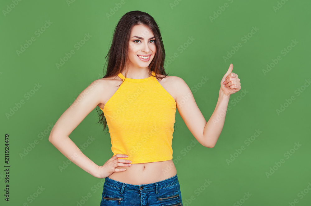 Adorable beautiful young cheerful brunette woman show thumb up on isolated green background. Lifestyle fashion Beauty People Business Students concepts Adorable beautiful young cheerful brunette woman show thumb up on isolated green background. Lifestyle fashion Beauty People Business Students concepts