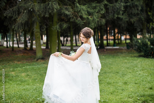 A beautiful bride in wedding dress dancing alone in field