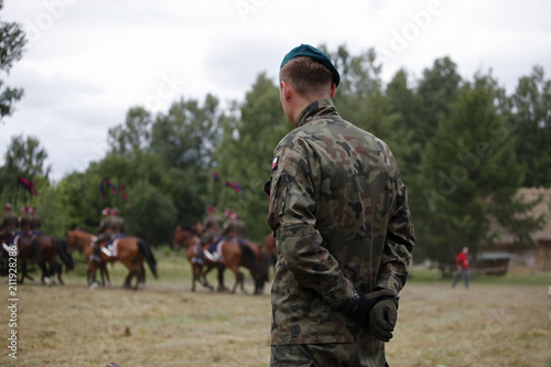 Konstfotografi The Polish military man in a green beret is standing with his back behind his back
