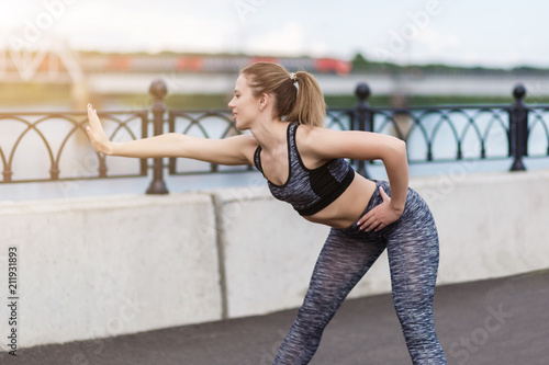 Girl athlete doing sports exercises workout on the waterfront © broniktav