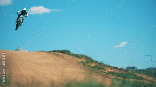 Slow motion footage of a motorcycler's leap above the hill. Slow motion photo