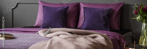 Fotografija Blanket thrown on king-size bed with purple bedding standing in dark grey bedroo