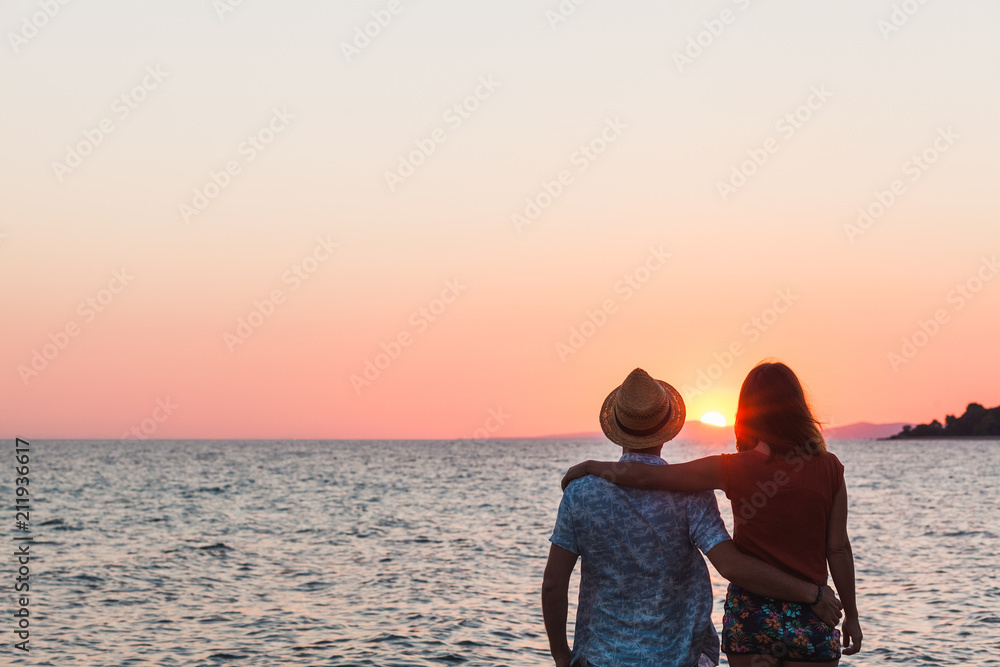 Young couple enjoying sunset by the sea