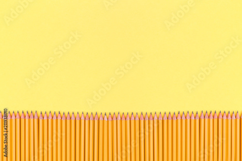 Row of pencils on a yellow background. Back to school concept