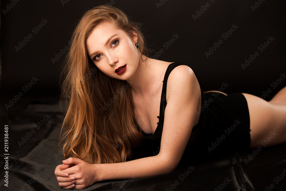 Fototapeta premium Boudoir photography of a beautiful young lady in black body over dark stylish background
