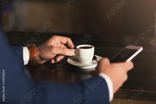 Man using mobile phone in coffee bar